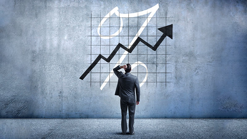 Homem a olhar para um gráfico na parede sobre o aumento de percentagem